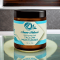Anume Naturals Unscented Beef Tallow moisturizer jar with blue and white label on reflective surface